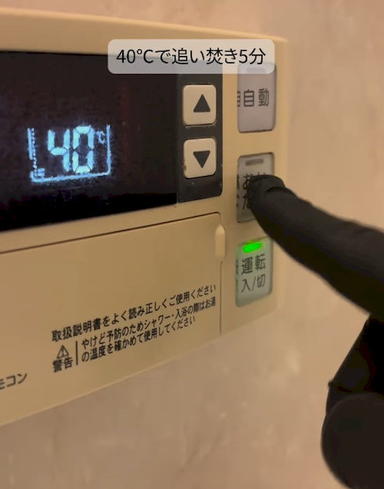 追い焚きボタンを押す様子