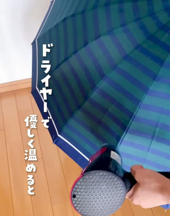 傘にドライヤーを当てている様子