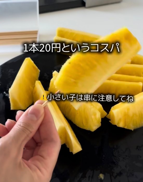 カットしたパイナップルに串を刺している様子
