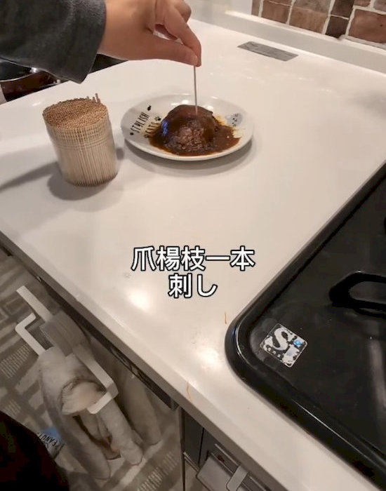 ハンバーグに爪楊枝を刺す様子