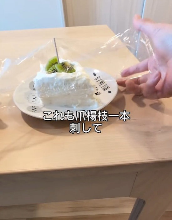 爪楊枝を刺したケーキにラップをかける様子