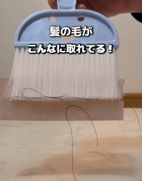 ほうきに貼ったテープにゴミが付いている様子