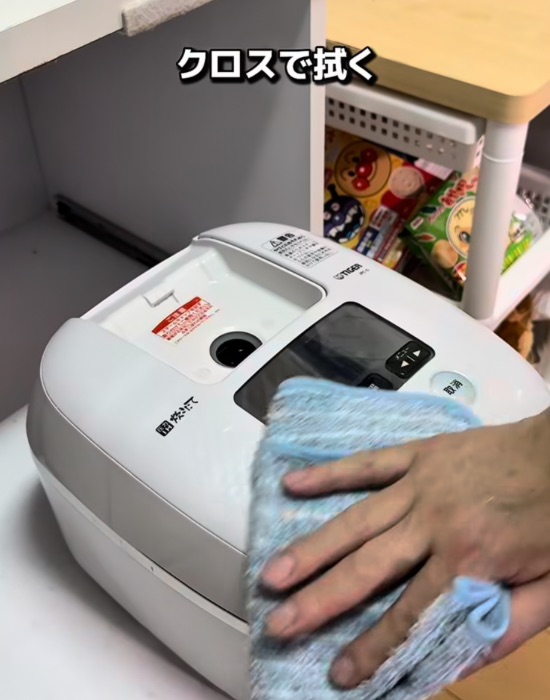 炊飯器本体の外側をマイクロファイバータオルで拭く様子
