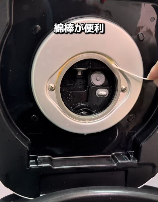 炊飯器の内側の隙間を綿棒で掃除する様子