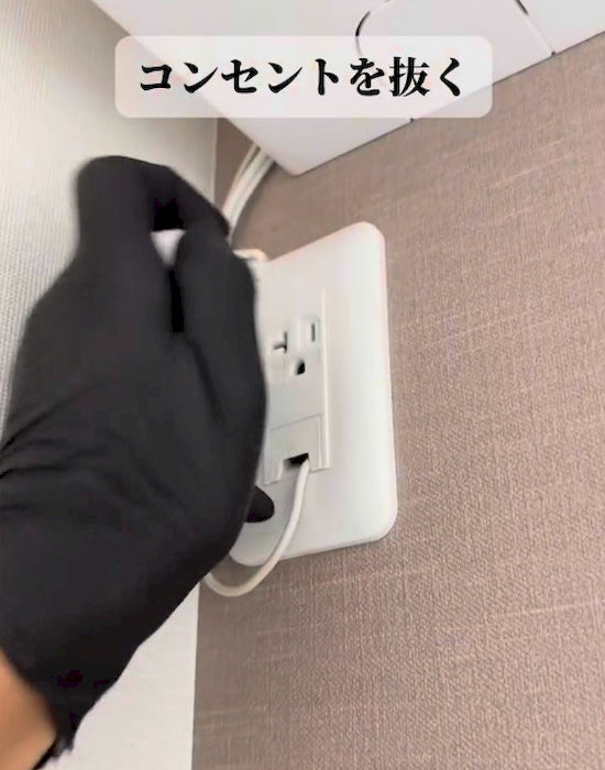 エアコンの電源プラグを抜いている様子