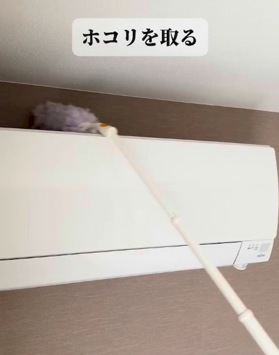 ハンディタイプのモップでエアコンを掃除している様子