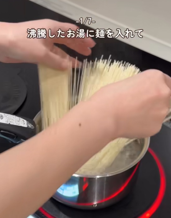 沸騰したお湯の入った鍋にそうめんを入れる様子