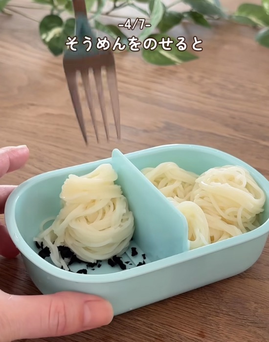 お弁当の底に乾燥ワカメを入れる様子