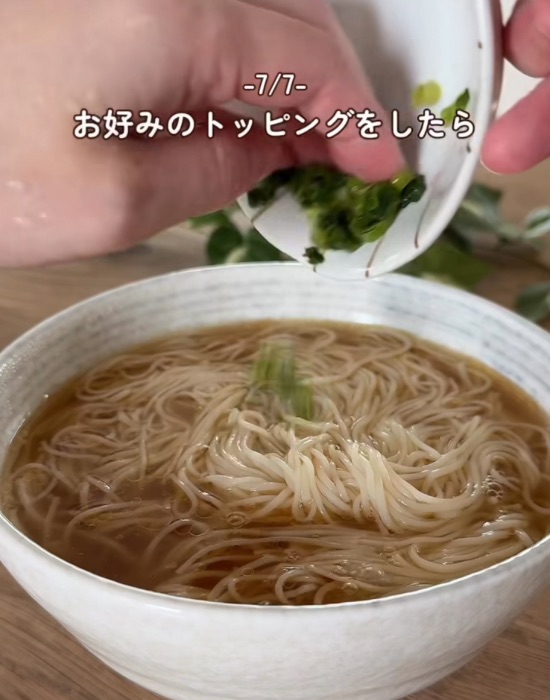 器に入ったそうめんにネギをかける様子