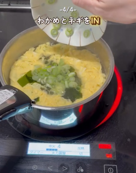 卵の入ったゆで汁の中にワカメとネギを入れる様子