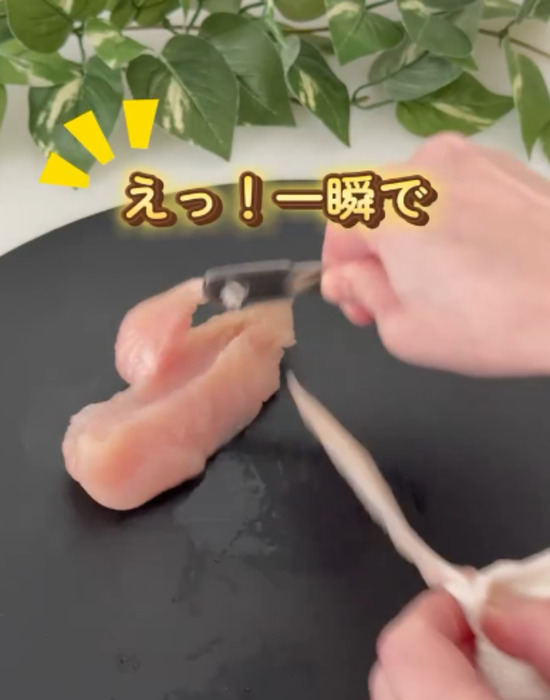 キッチンペーパーでささみの筋を挟んで引っ張る様子