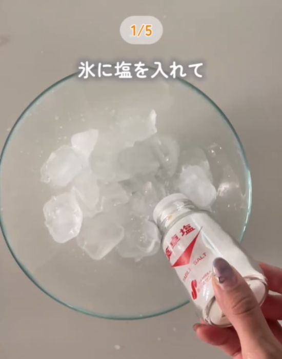 ボウルに入った氷の上に塩をかける様子