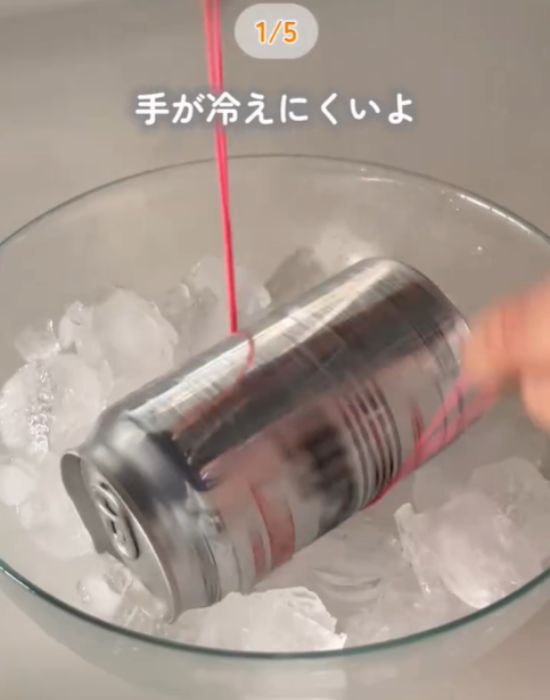 輪ゴムを使って氷の中に入った缶を回す様子