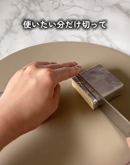 バターを銀紙の上から切っている様子