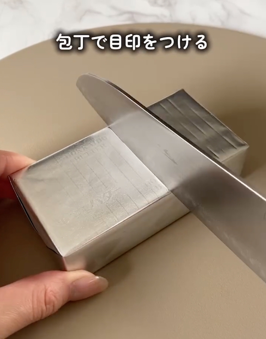 バターを銀紙の上から切っている様子