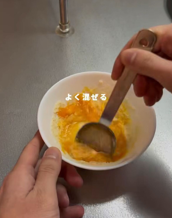 卵と粉チーズを混ぜる様子