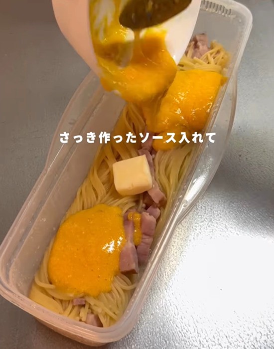 パスタにバターとソースを入れる様子