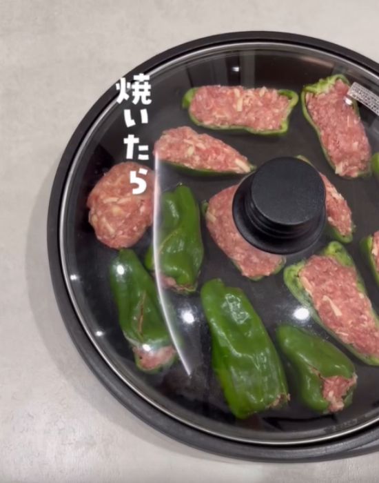 肉詰めしたピーマンをフライパンで焼く様子