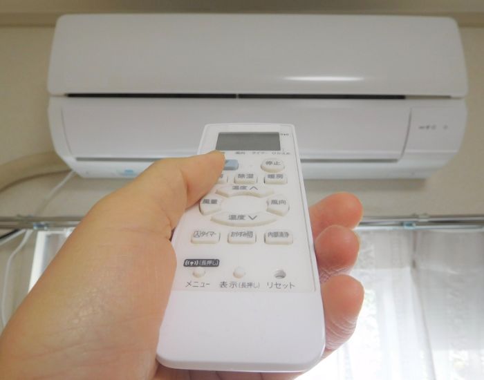 エアコンのリモコンをエアコンに向けた様子