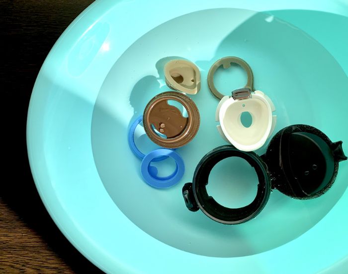 水筒のパーツを分解して水を張った容器に浸けている様子
