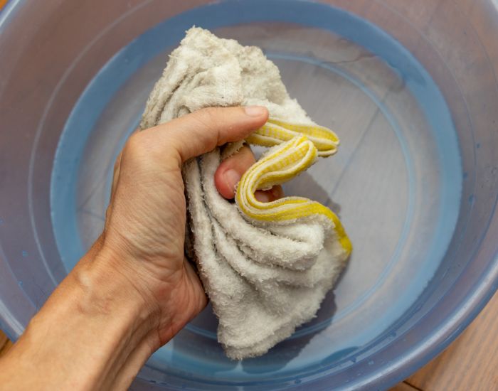水に濡らした雑巾を片手で握りしめる様子