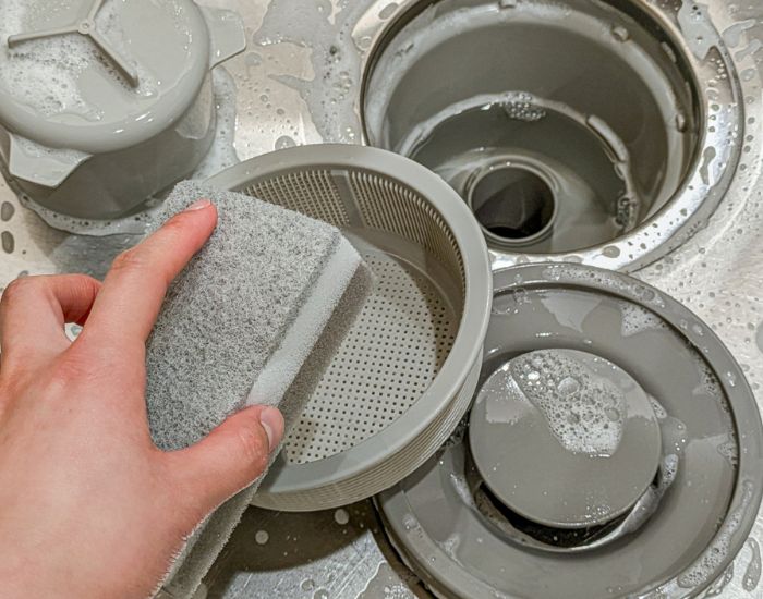 排水口の部品を分解して洗っている様子
