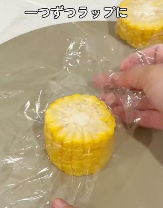 切ったトウモロコシをラップで包む様子