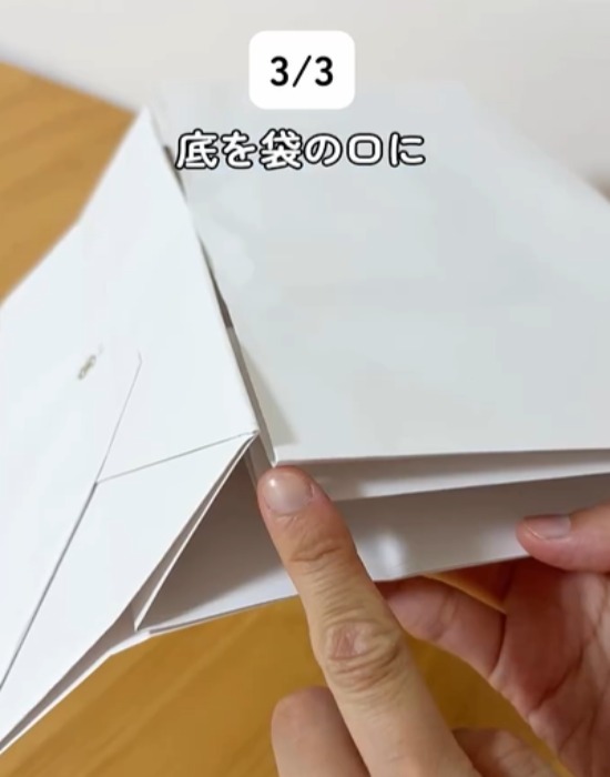 紙袋の底を指さす様子