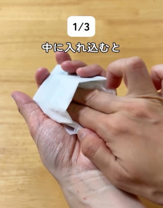 ポケット状に折ったレジ袋に持ち手を入れ込む様子