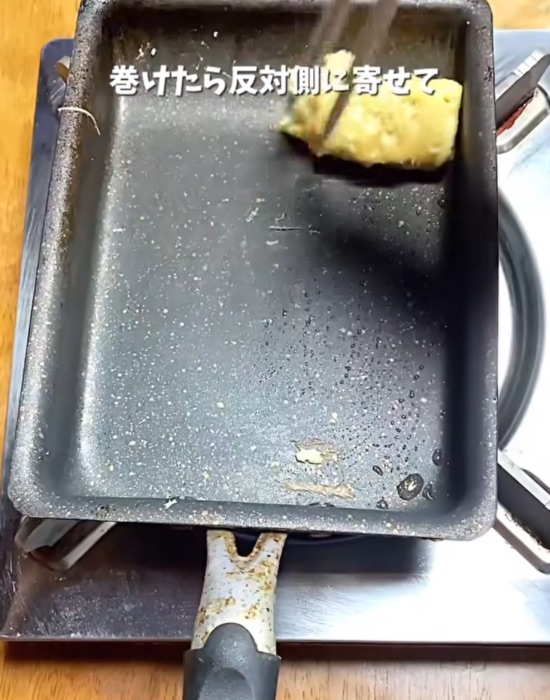 巻いた卵を端に寄せる様子