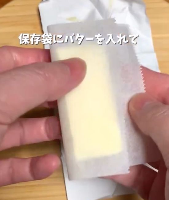 バターの間に挟んだクッキングシートで一切れずつバターを包む様子