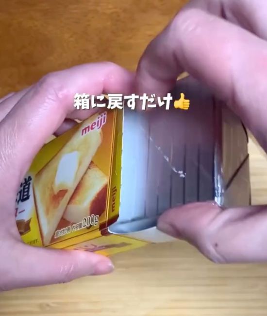 銀紙の上から切ったバターを箱に戻す様子