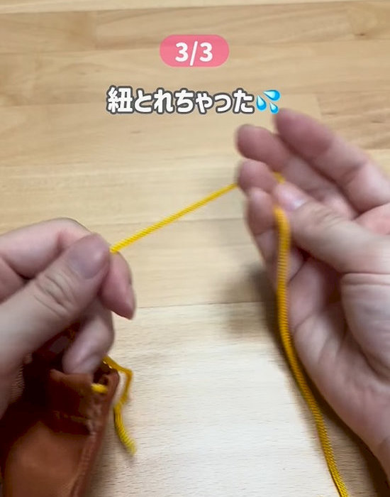 袋から取れた紐を持つ人