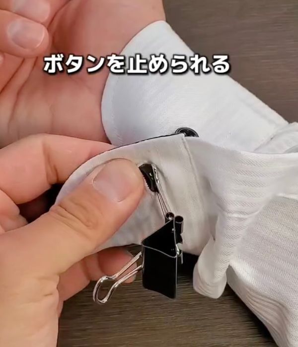 ボタンにワイヤーが引っかかっている状態で袖ボタンを留める様子