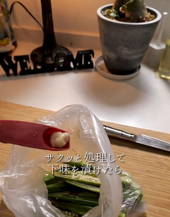 ビニール袋に入れたオクラに調味料をかける様子