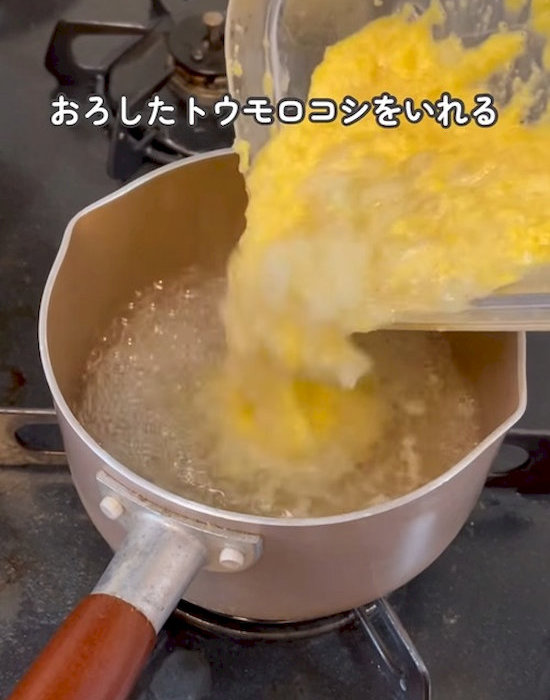 鍋にすりおろしたトウモロコシとタマネギを入れる様子