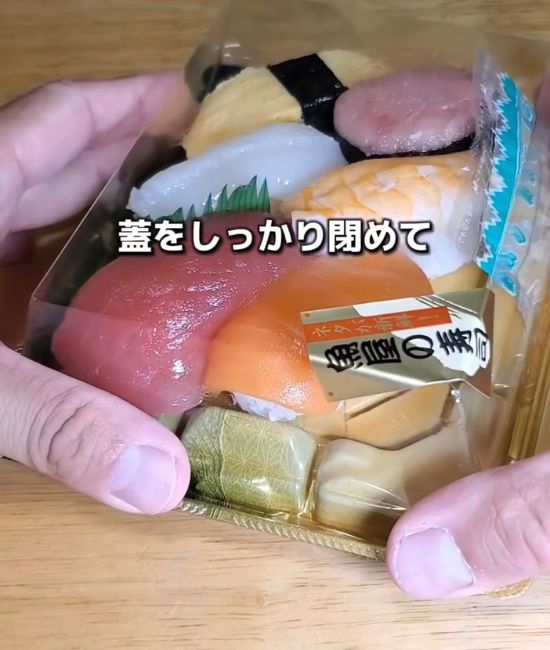 パック寿司のフタを閉める様子