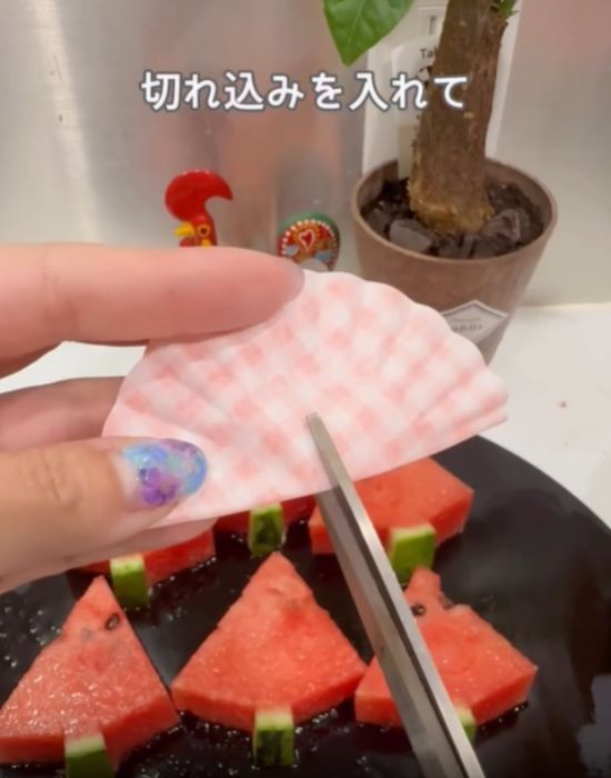 お弁当用のカップに切り込みを入れる様子