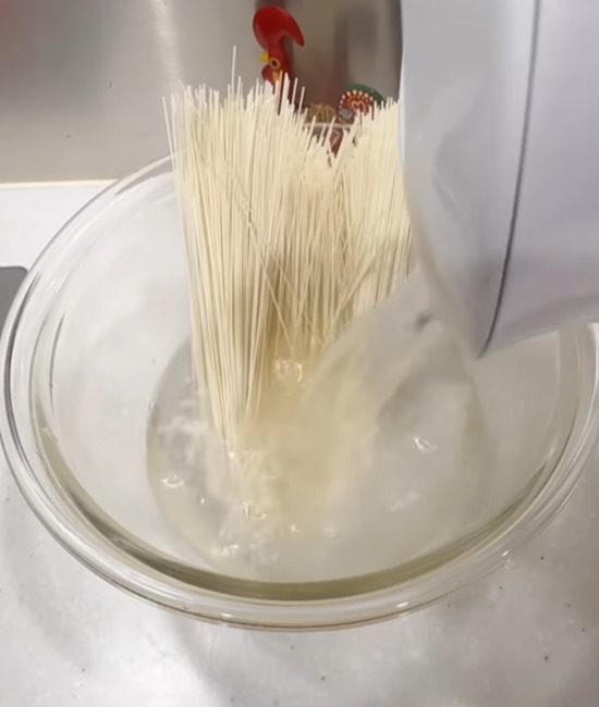 そうめんの入ったボウルにお湯を入れる様子
