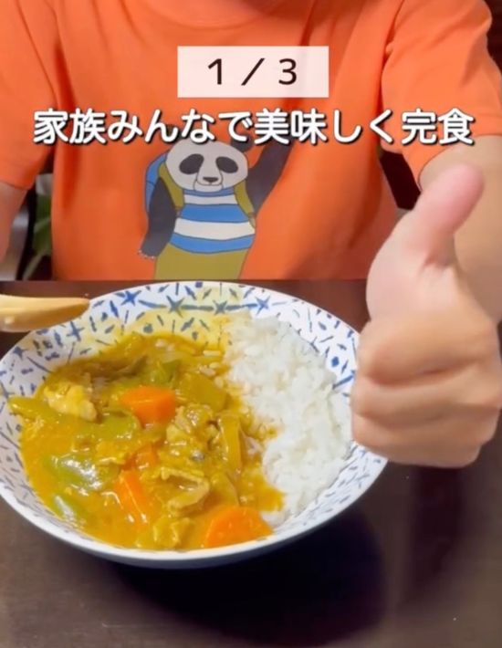 お皿に盛られたカレーを前に子供がグッドサインを向ける様子
