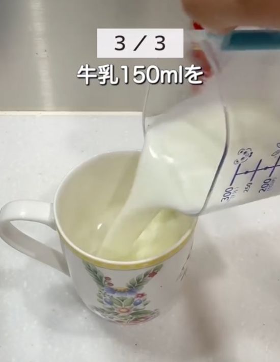 マグカップに計量カップで牛乳を入れる様子