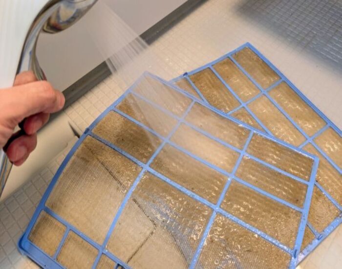 エアコンのフィルターを掃除する様子