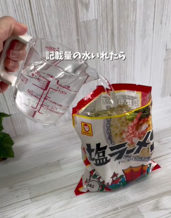麺の入った袋に水を入れる様子