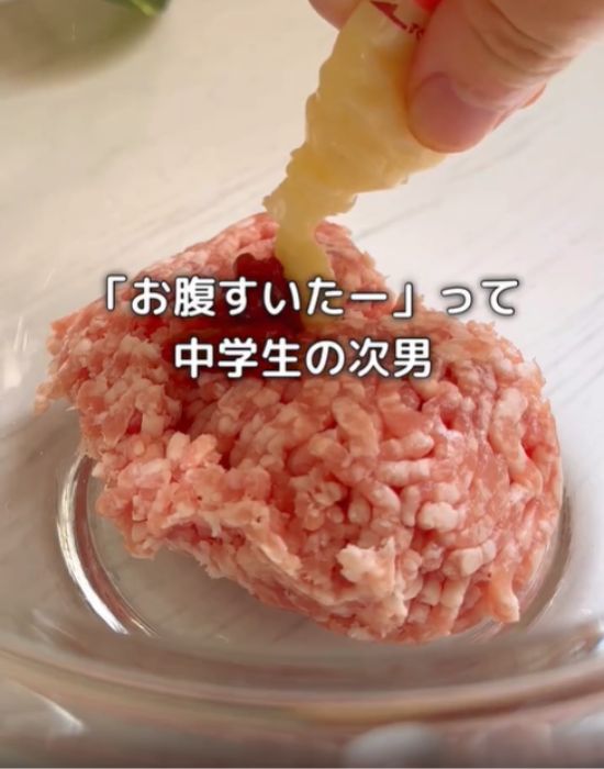 豚ひき肉にチューブニンニクを入れる様子
