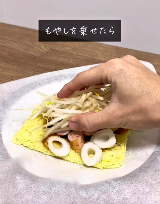 焼きそば麺の上に具材をのせる様子