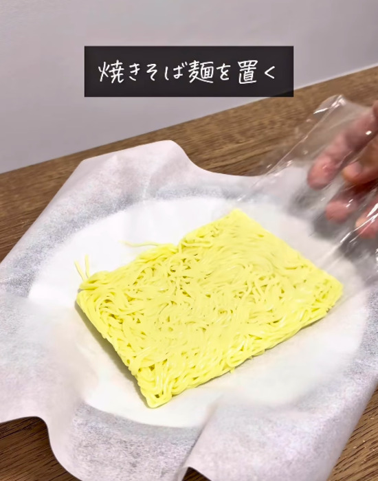 クッキングシートに焼きそば麺を置く様子