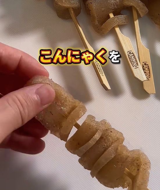 こんにゃくを串に刺す様子