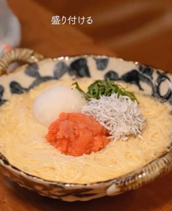 卵と調味料を混ぜ合わせたそうめんの上に大根おろしとしらすと明太子と大葉を盛りつけた様子
