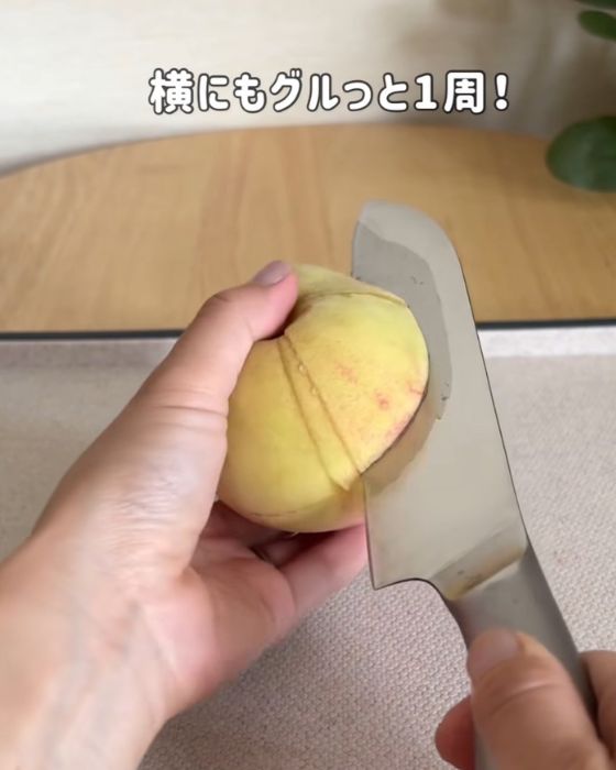 桃に十字に切り込みを入れて横にも一周切り込みを入れる様子
