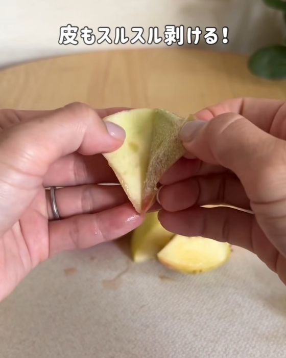 桃の皮を手でむく様子